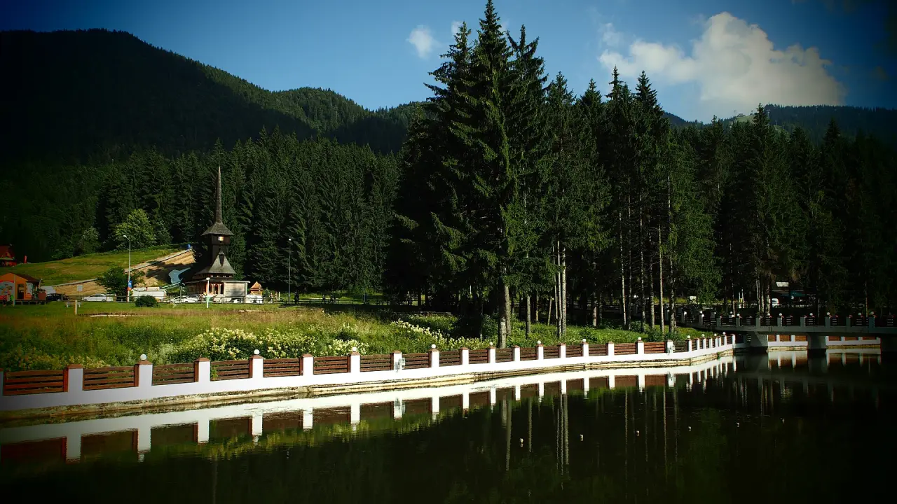 Snow-covered forest and mountain hotels at Poiana Brasov under a clear winter sky