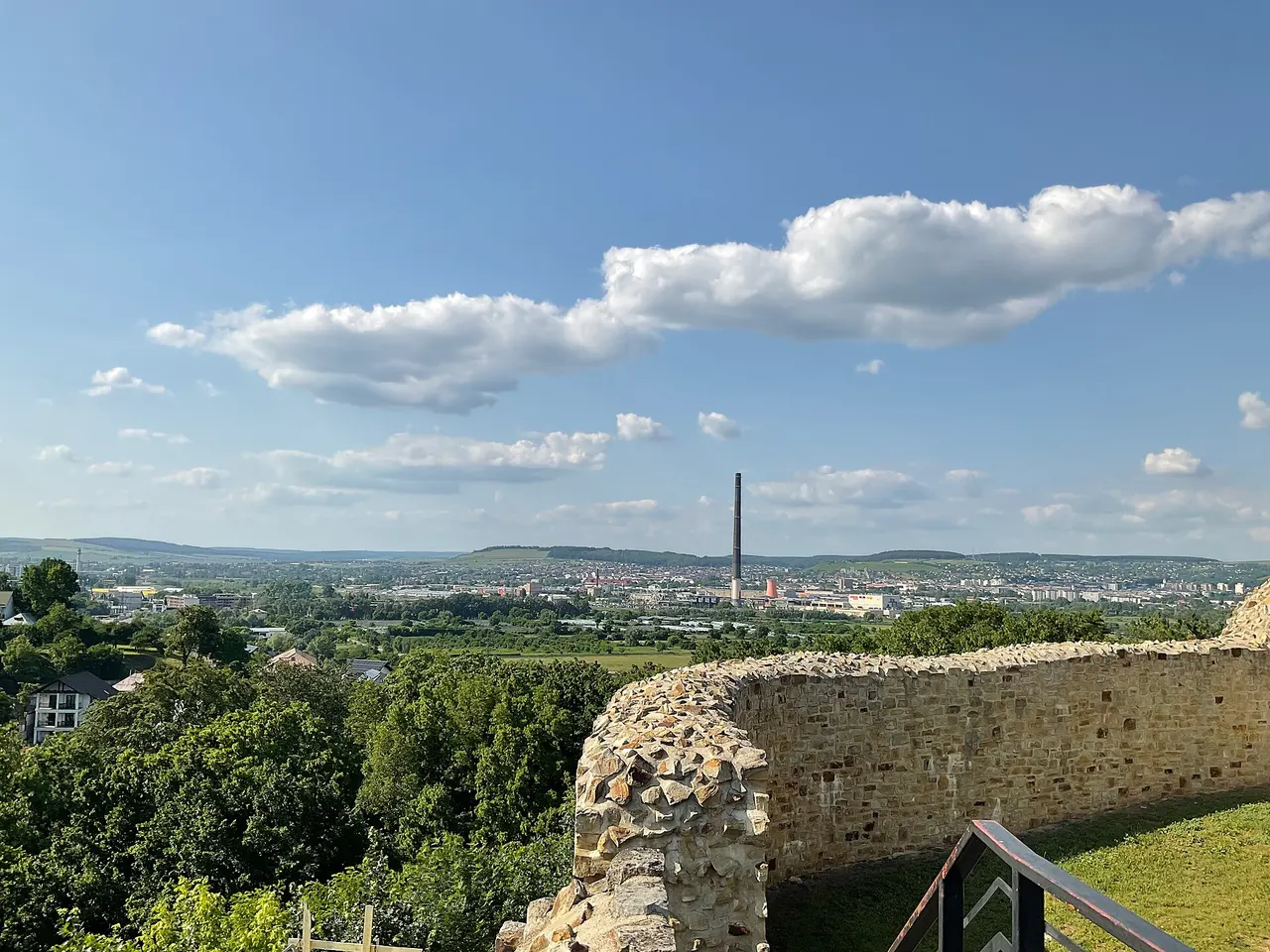Panorama of modern Suceava spread below the fortress walls, apartment blocks and church spires in the valley