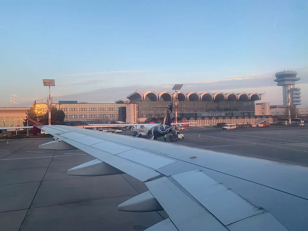 The terminal building at Henri Coanda airport in Otopeni, north of Bucharest, with cars and passengers outside