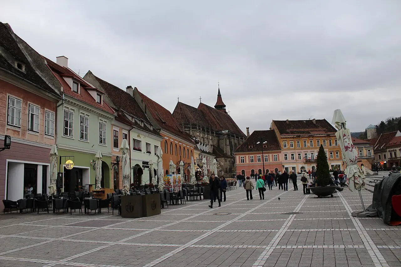 Council Square in Brasov ringed by pastel merchant houses with the Council House tower in the middle