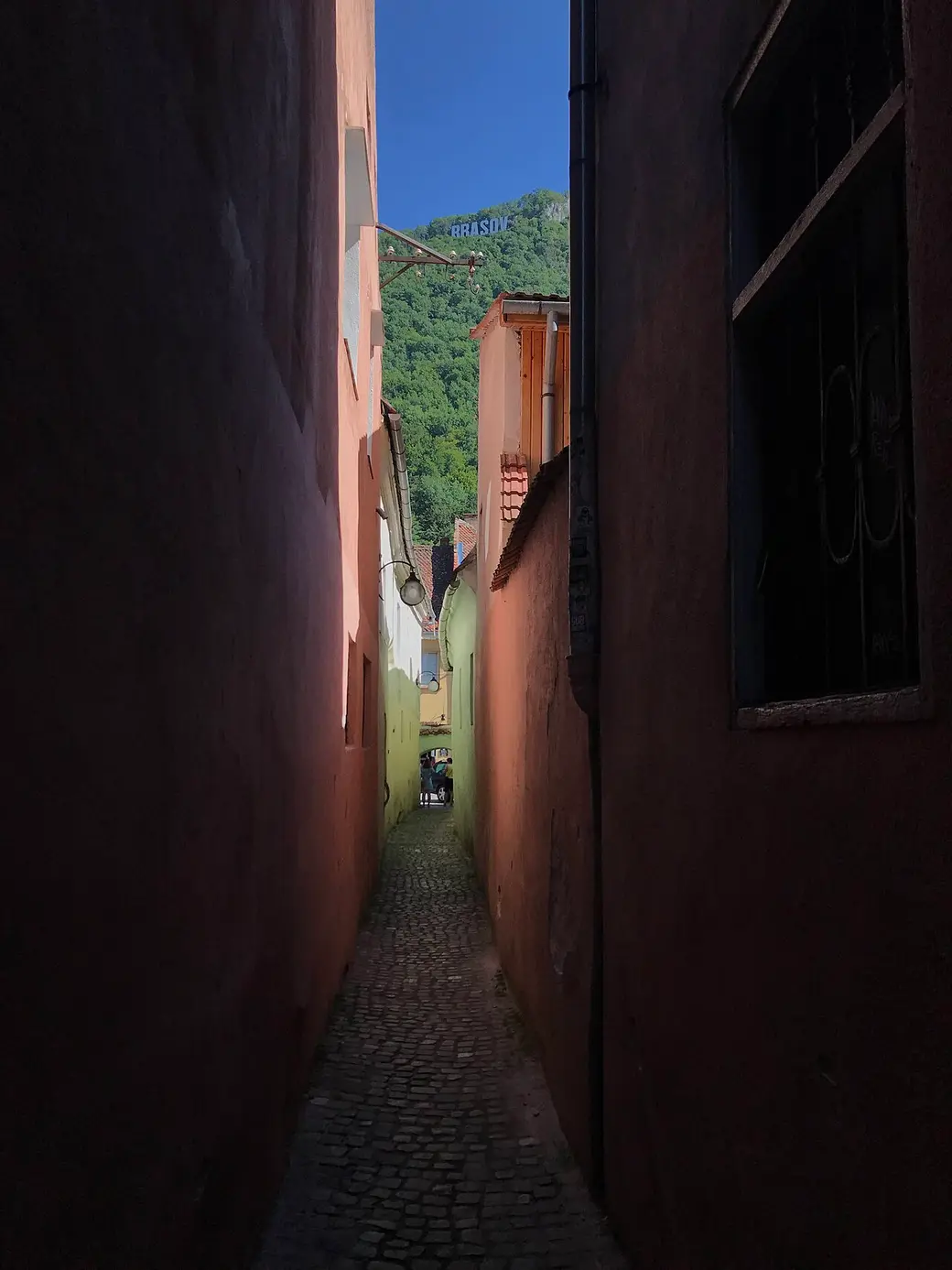 Looking down the narrow length of Rope Street in Brasov between two plastered walls