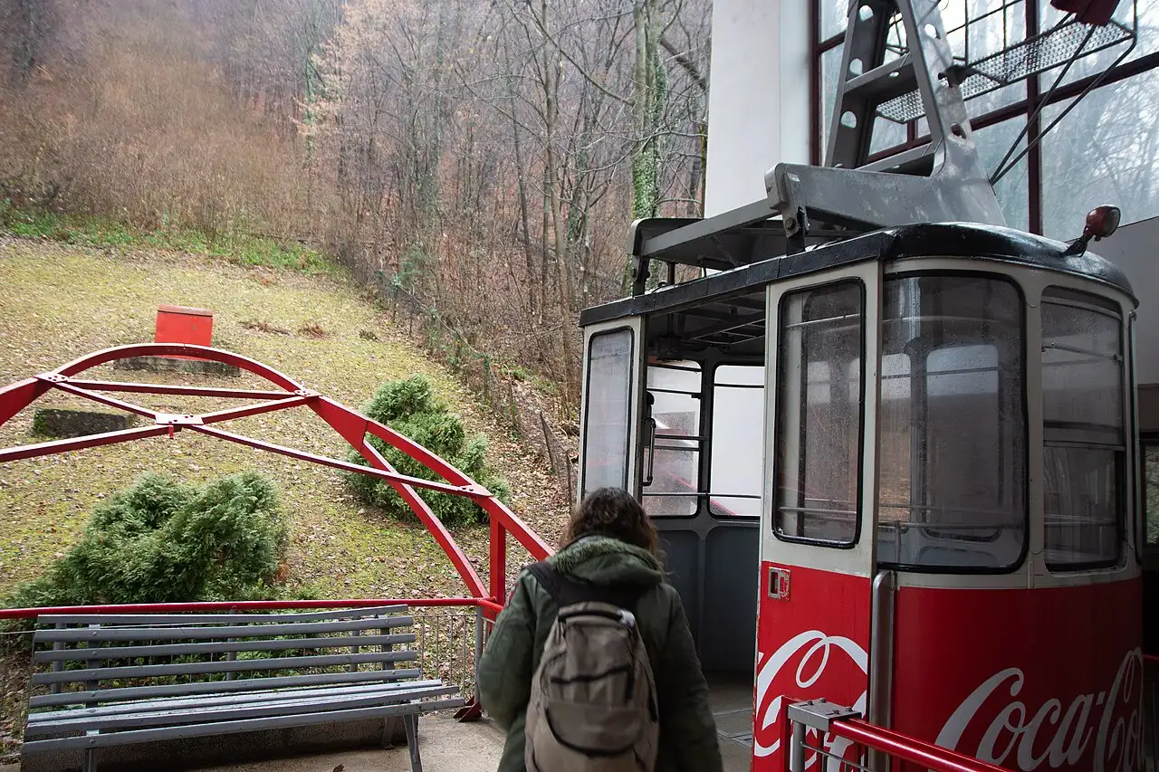 The Tampa cable car cabin climbing above the forest over Brasov