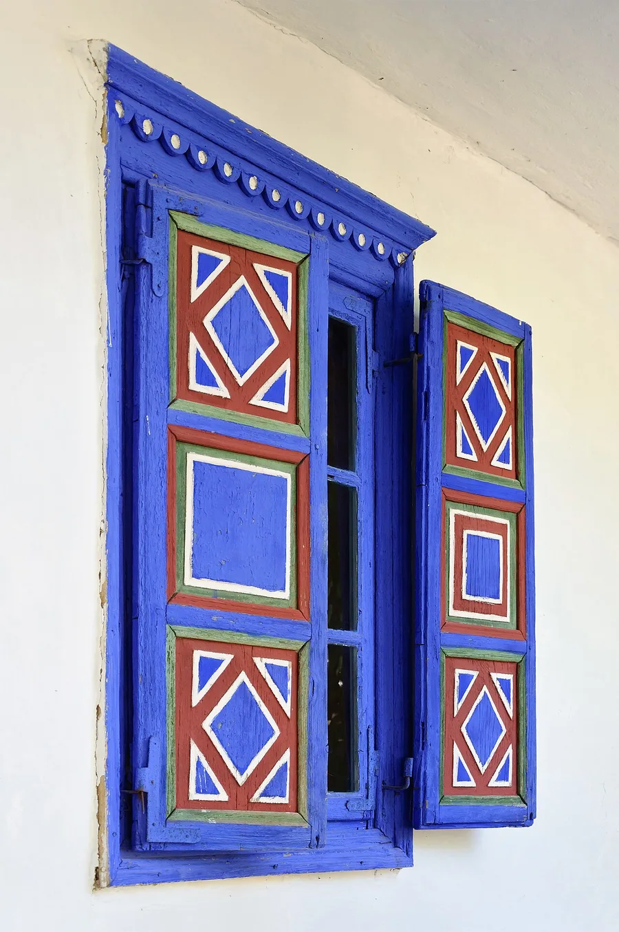 A blue-painted wooden window on a traditional house at the Village Museum