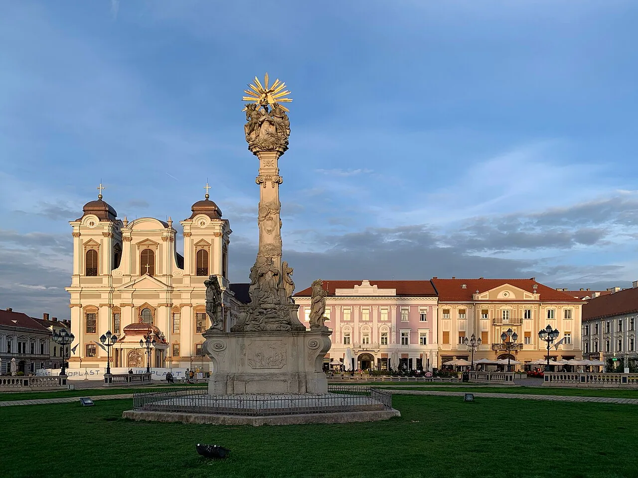 Restored Baroque and Secession facades on Piata Unirii in Timisoara, pastel buildings in pink, cream and blue under a clear sky