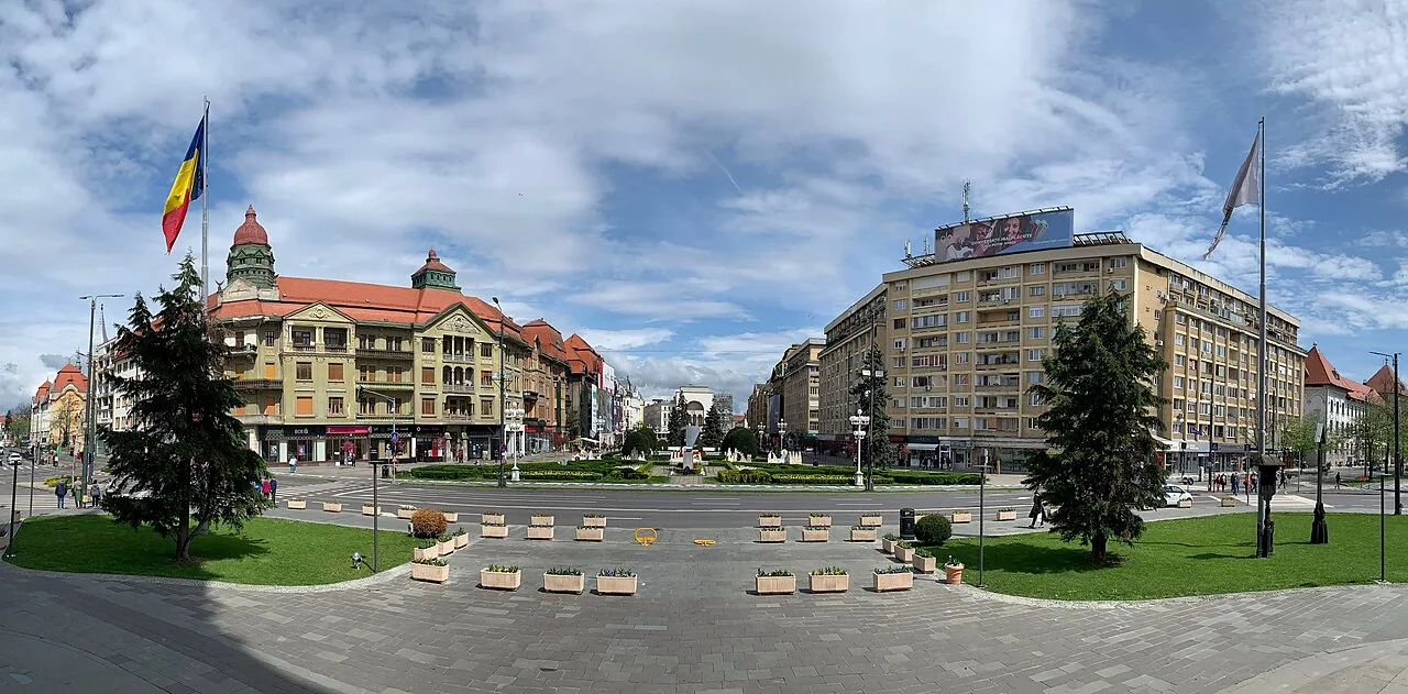 Piata Victoriei in Timisoara seen along its length, a wide pedestrian esplanade with flower beds, fountains and restored facades on both sides