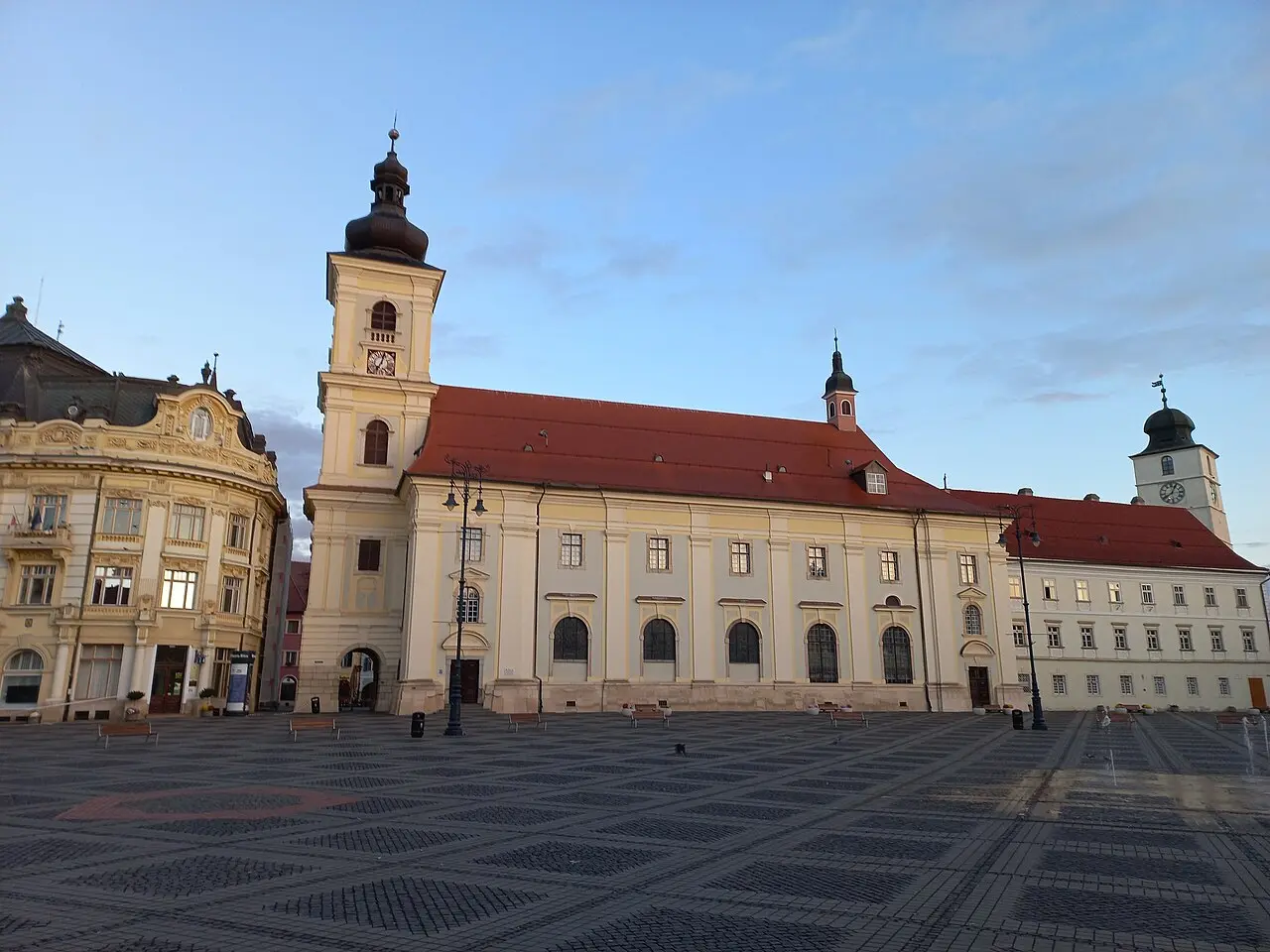 Sibiu city hall and former Jesuit church on the main square under a summer sky