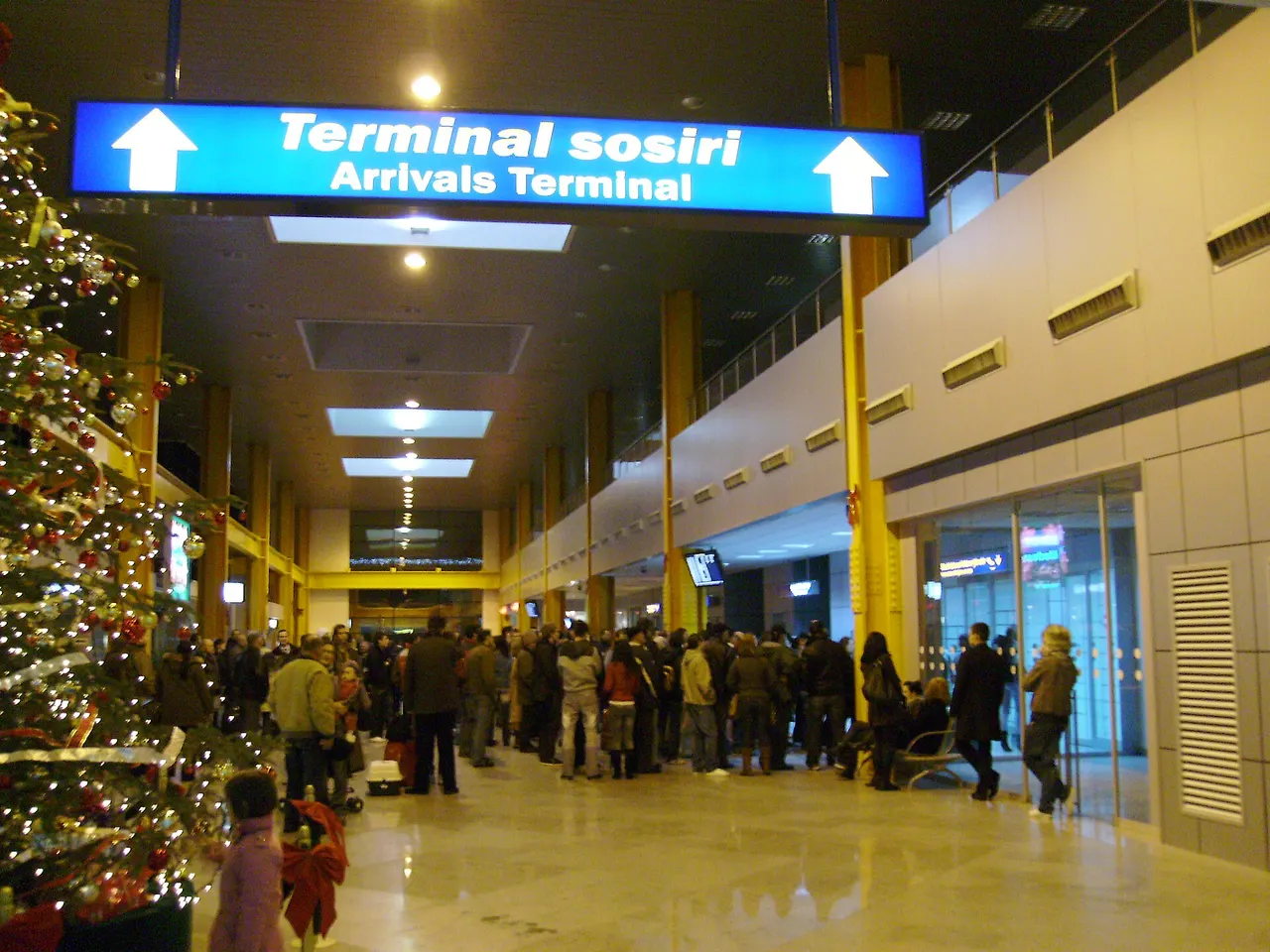 The busy arrivals hall at Cluj Avram Iancu International Airport, travellers gathered under an Arrivals Terminal sign