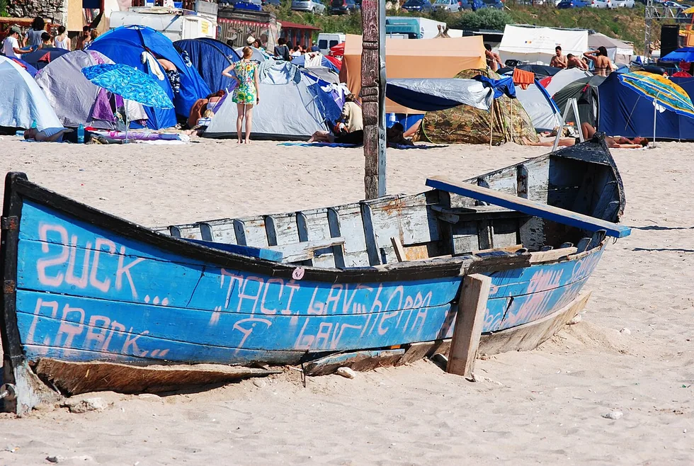 A small wooden fishing boat pulled up on the sand at Vama Veche, close to the water's edge
