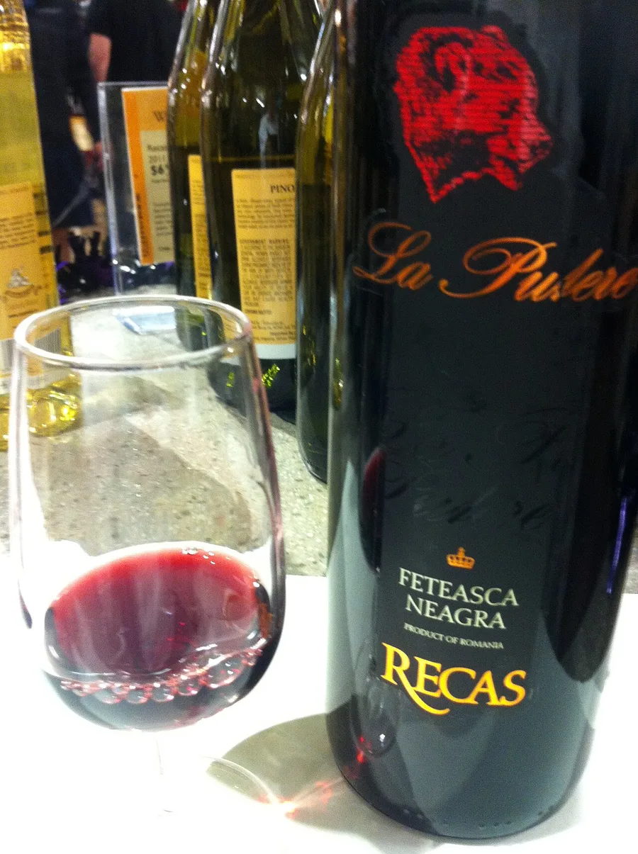 A bottle of Feteasca Neagra red wine from Romania beside a glass of red