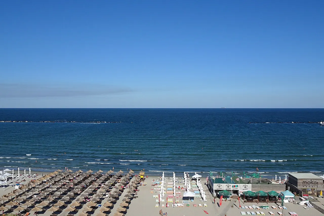 Sunbeds on the wide Mamaia beach facing the Black Sea under a clear summer sky