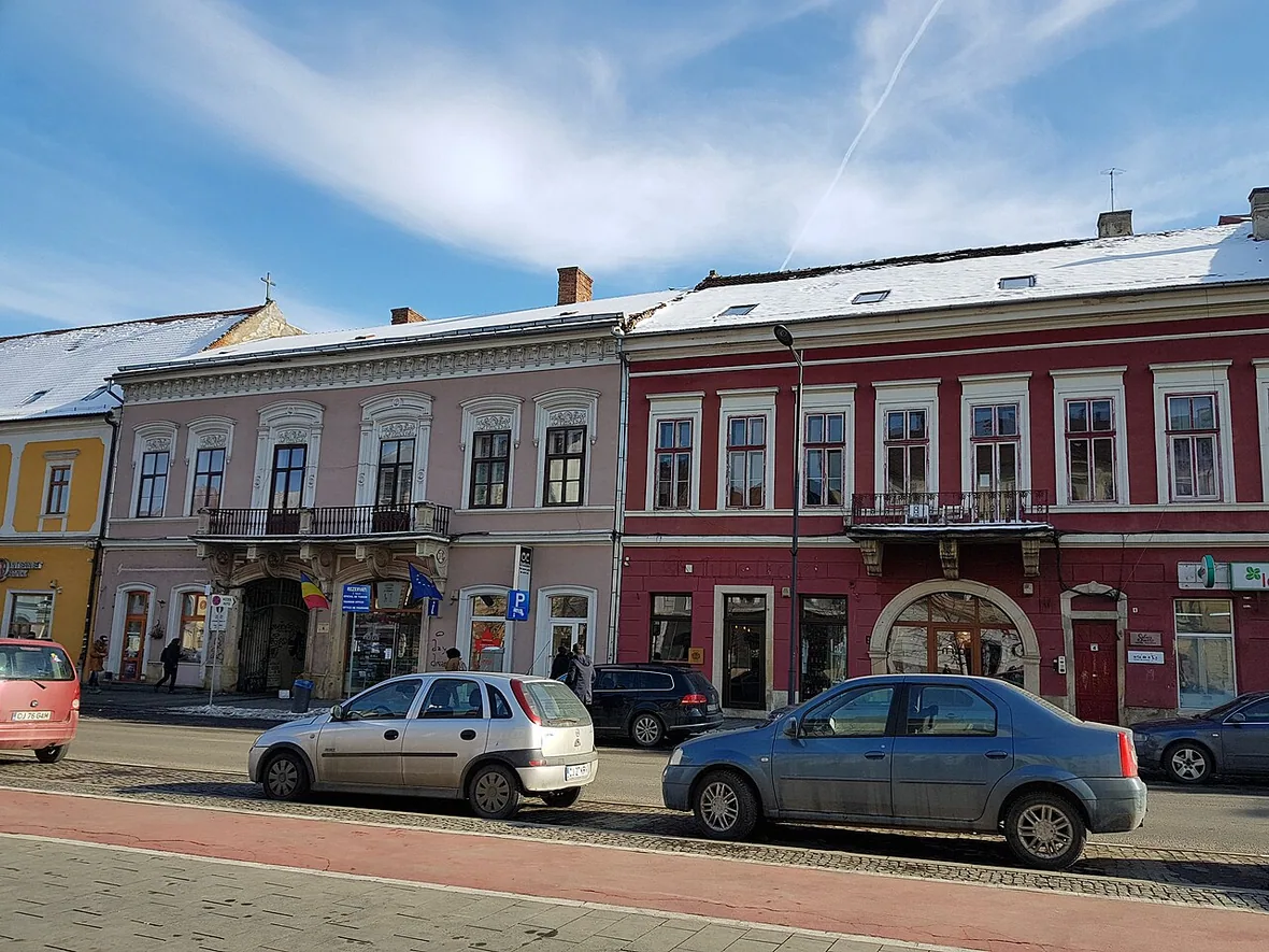 A street of restored historic buildings in central Cluj-Napoca, the kind of central block where many hotels and guesthouses sit