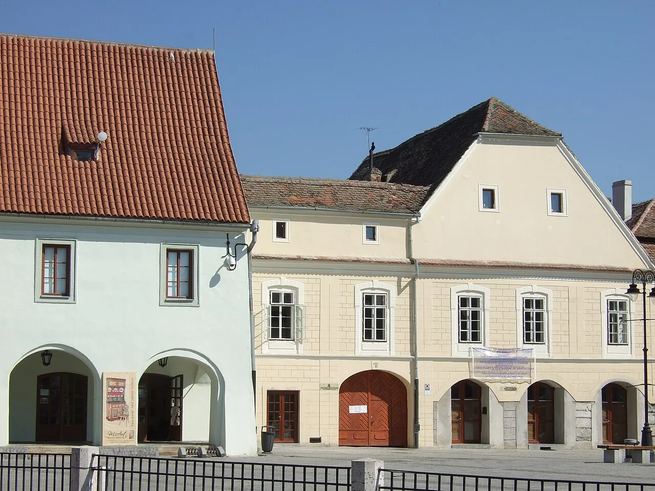 The pastel facades and cafe terraces of Piata Mica, the Small Square in the Upper Town of Sibiu, on a sunny day