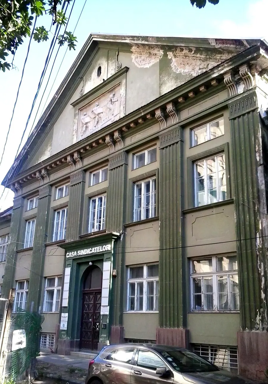 A pale green Art Nouveau building with fluted pilasters on a quiet side street in Cetate, Timisoara, a block back from the main squares