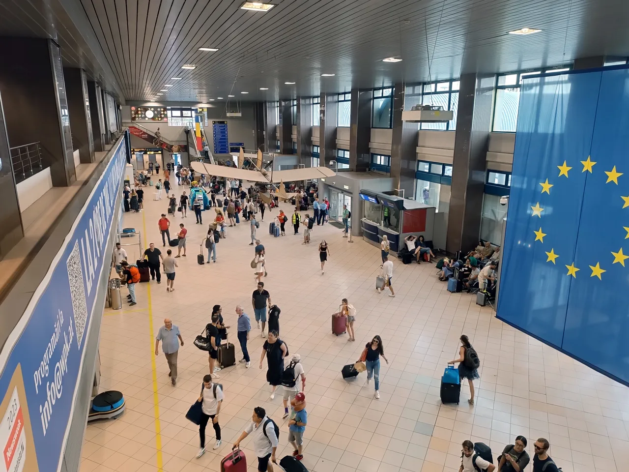 The bright check-in hall of Bucharest Henri Coanda airport (OTP), rows of desks under a high white ceiling, the airport most visitors to Romania fly into